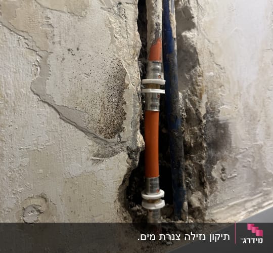 צינור כתום עם מחבר בקיר חשוף